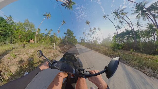 Bare Hands Steer a Scooter Along a Tropical Palm Lined Rural Road, First Person Wide Angle View Supporting Adventure Travel and Outdoor Lifestyle Vertical video.