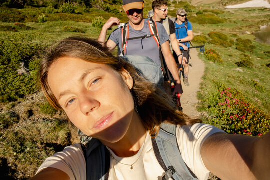 Woman taking UGC selfie with friends hiking in Pyrenees