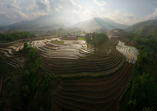 Water-Filled Rice Terraces Cascade Through Mountain Valleys