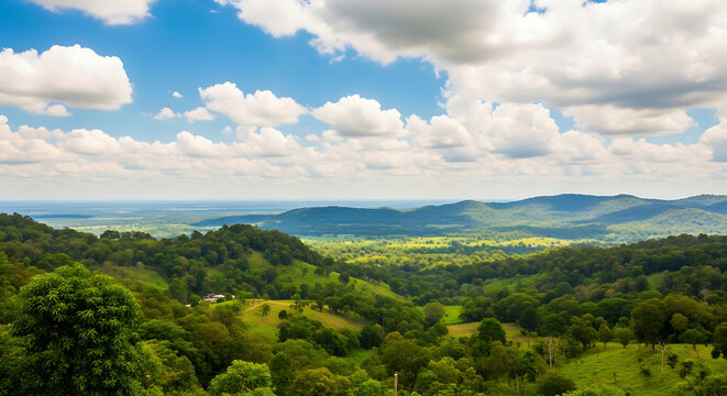 Lush green rolling hills and distant mountains under a bright blue sky with fluffy clouds
