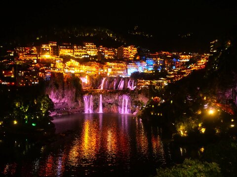 Furong Ancient Town Illuminated Waterfall and Traditional Chinese Architecture at Night, Hunan, China