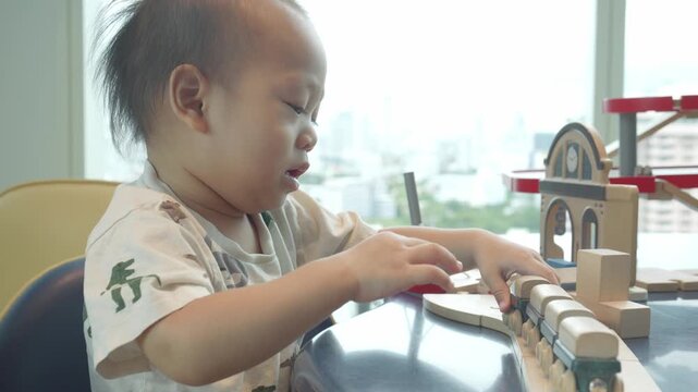 A young child focuses intently on arranging wooden building blocks, showcasing creativity and concentration in a bright, modern environment with city views.