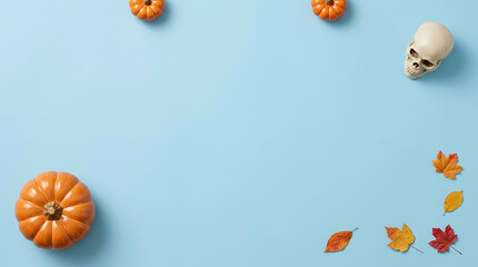 Fototapeta premium Halloween flat lay composition with pumpkins, skull, and autumn leaves on a light blue background