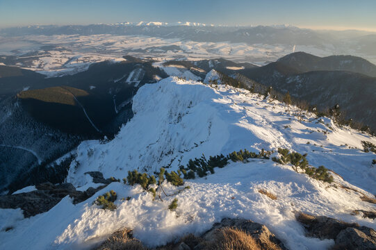 View of the snow-covered peak of Velky Choc with the Western Tatras visible on the horizon during a clear winter day in Chocske Vrchy, Zilina Region, Slovakia.