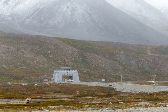 View of the Khunjerab Check Post at the China-Pakistan border on the Karakoram Highway, set against a backdrop of rugged, snow-dusted mountains in Hunza Nagar, Gilgit Baltistan, Pakistan.