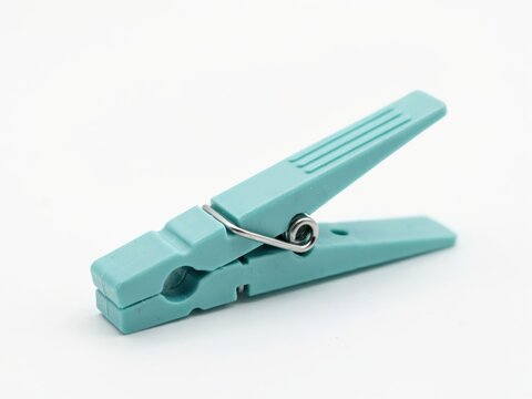 Single light blue plastic clothespin isolated on white background