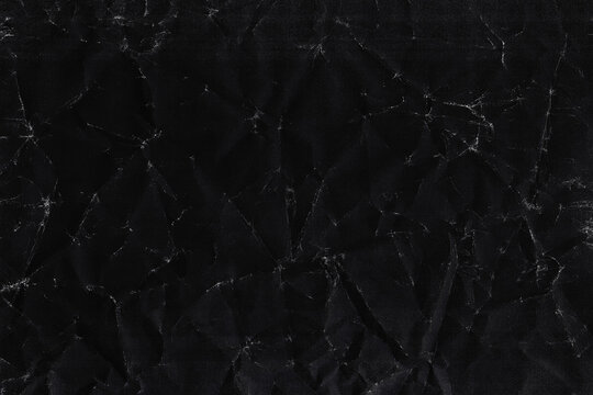 Dark crumpled paper background with faint scattered crease marks