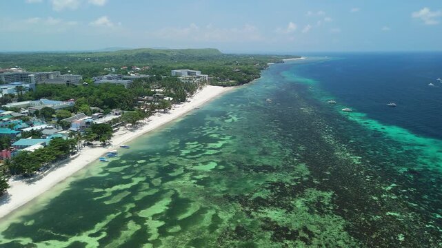 Aerial view of Alona Beach with white sand, turquoise waters, and coastal resorts in Panglao, Bohol, Philippines.