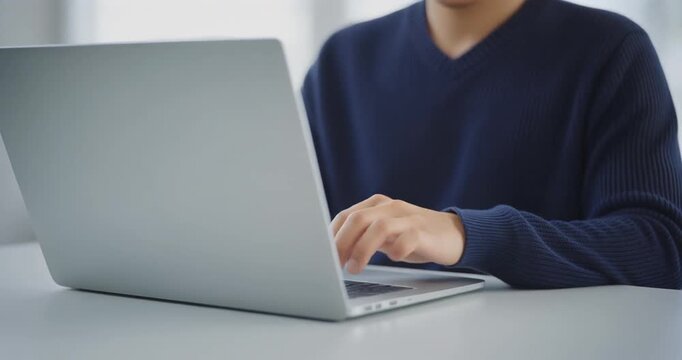 Executive man typing on silver laptop for professional corporate workflow