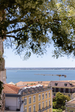 wide landscape shot of Lisbon, Portugal with orange tiled roofs looking towards Tagus River on a sunny clear day