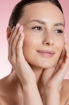 Close up of a woman's face with hands gently touching her skin