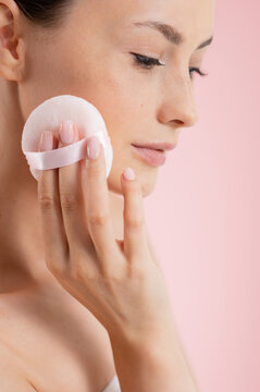 Woman applying powder with a soft puff for a flawless complexion