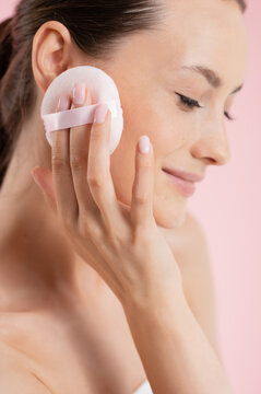 Woman applying powder with a soft puff for a flawless makeup look