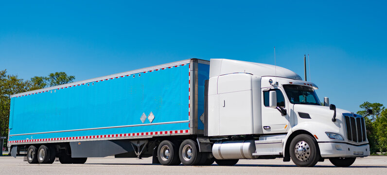 American style truck. Transport concept. Road freight cars. Trucking with semitruck vehicle. Semi truck in America. Freightliner trailer transportation. Rig truck semi trailer hauling