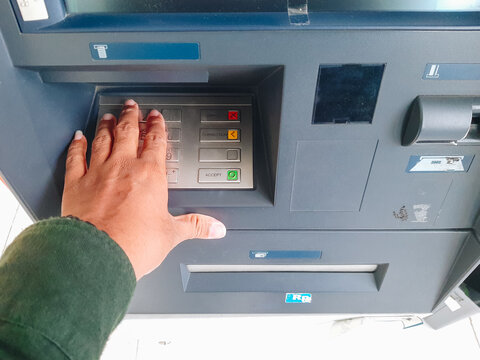 Human hand inserting bank card into atm for cash withdrawal
