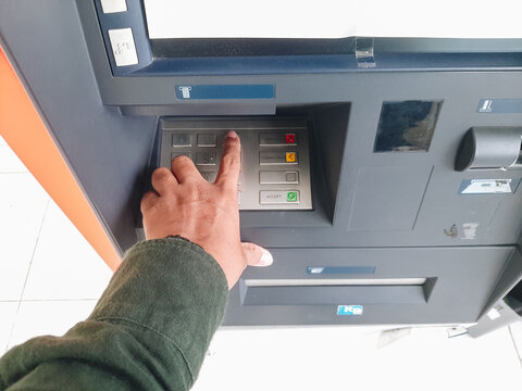 Human hand inserting bank card into atm for cash withdrawal
