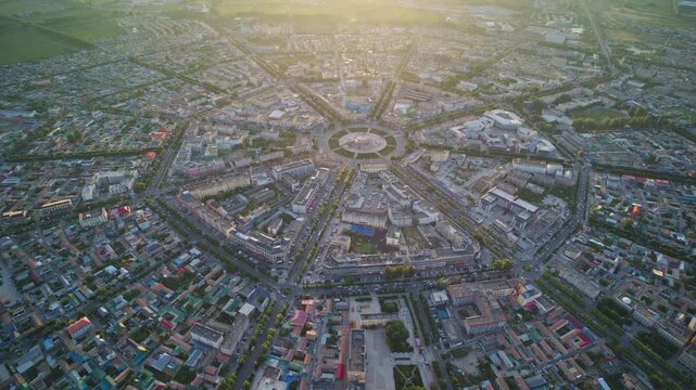 High-Angle Aerial Panoramic View of Tekes Bagua City at Golden Sunset, Ili Unique Bagua I-Ching Geometric Layout, Warm Twilight, Mountain Range and Horizon in Xinjiang
