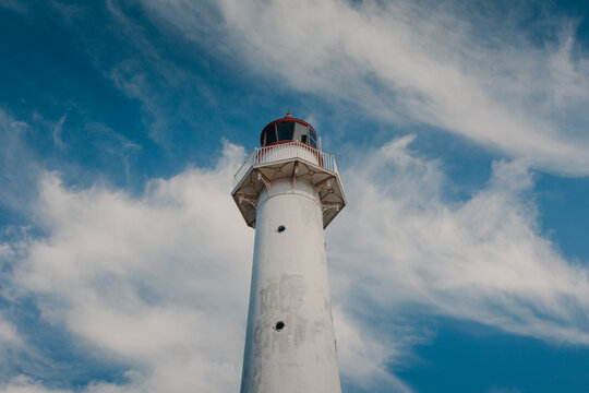 View of Saxby Lighthouse against a bright blue sky with wispy white clouds in Saxby, Laane maakond, Estonia.