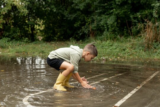 Child Playing in a Puddle Outdoors