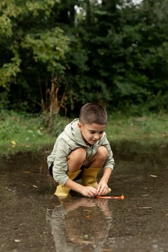 Child Playing in a Puddle Outdoors