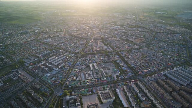 High-Angle Aerial Panoramic View of Tekes Bagua City at Golden Sunset, Ili Unique Bagua I-Ching Geometric Layout, Warm Twilight, Mountain Range and Horizon in Xinjiang