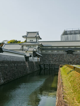 View of Kanazawa Castle with its traditional white walls, tiled roofs, stone foundations, and a calm moat in Kanazawa, Ishikawa, Japan.