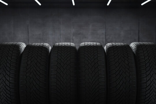 Tire at repairing service garage background. Winter and summer tyre in the warehouse. Transportation and automotive maintenance concept