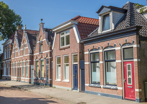 Historic brick houses on a quiet sidewalk street in Meppel, Netherlands