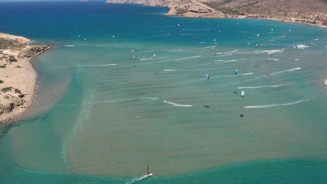 14 June 2026 Prasonisiou, Rodos: Dynamic aerial drone footage of windsurfers riding the waves at Prasonisi Beach in Rhodes, Greece. Bird's-eye view of windsurfing action, turquoise Mediterranean water
