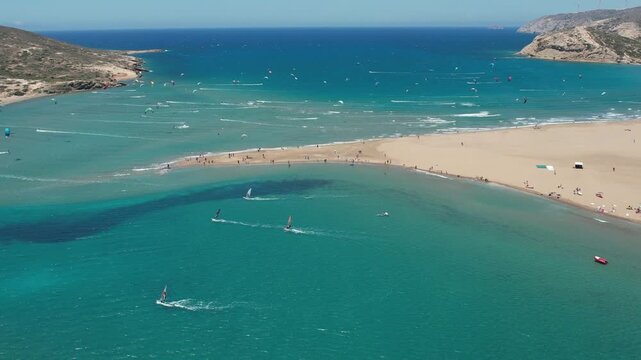 14 June 2026 Prasonisiou, Rodos: Dynamic aerial drone footage of windsurfers riding the waves at Prasonisi Beach in Rhodes, Greece. Bird's-eye view of windsurfing action, turquoise Mediterranean water