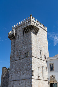 View of the historic marble Torre das Tres Coroas in Estremoz Castle, featuring stone masonry and battlements under a clear blue sky in Estremoz, Evora District, Portugal.