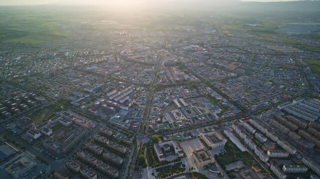 High-Angle Aerial Panoramic View of Tekes Bagua City at Golden Sunset, Ili Unique Bagua I-Ching Geometric Layout, Warm Twilight, Mountain Range and Horizon in Xinjiang