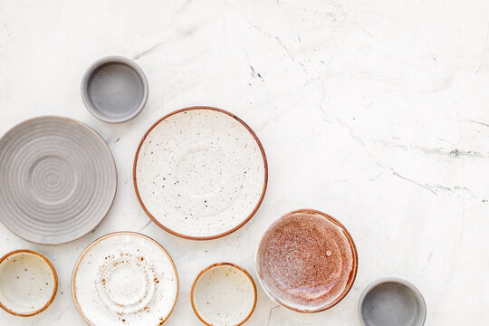 Kitchen concept. Crockery kit. Empty ceramic plates and mugs on white background top view copy space