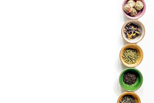 herbs in colorful bowls to make tea on white table background top view mock-up