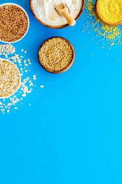 Healthy food. Cereals - rice, oats, buckwheat - in bowls on blue background top view frame copy space