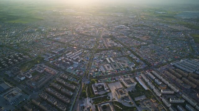 High-Angle Aerial Panoramic View of Tekes Bagua City at Golden Sunset, Ili Unique Bagua I-Ching Geometric Layout, Warm Twilight, Mountain Range and Horizon in Xinjiang