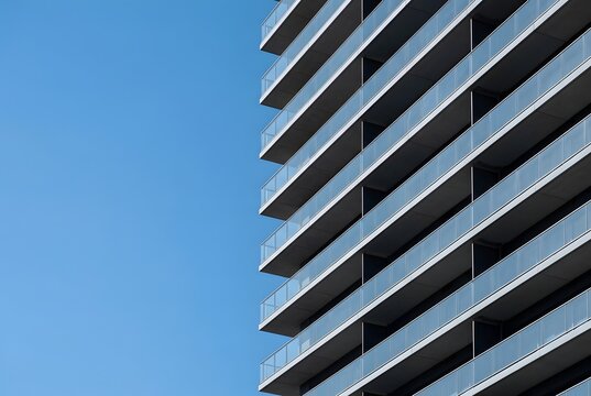 Modern Apartment Building With Repeating Glass Balconies Against Blue Sky