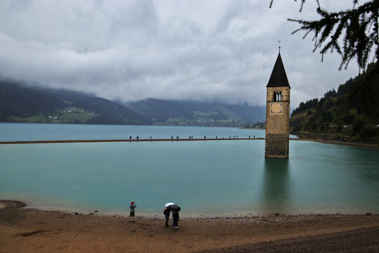 The famous submerged bell tower of Lake Resia on a rainy day, Curon Venosta.