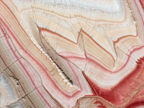 Aerial view of the colorful sedimentary rock layers of the Kyzyl Kup Tiramisu formation with intricate patterns and red and white stripes in Karakiya District, Mangystau Region, Kazakhstan.