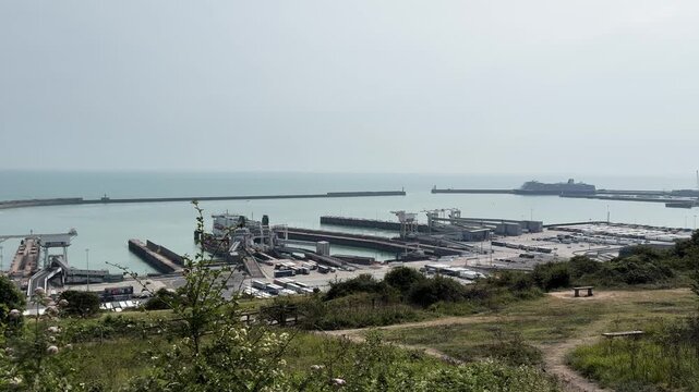 High angle wide view of busy Port of Dover with passenger ferries, cargo trucks, and logistical infrastructure on English coast.