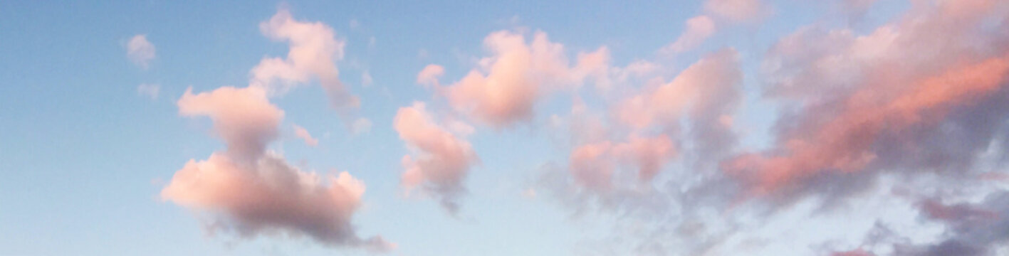 wide photo of clouds in a blue sky at sunset