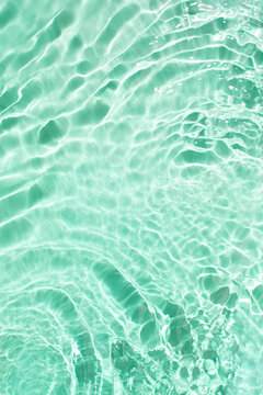 Abstract wave water on a pastel turquoise green background.