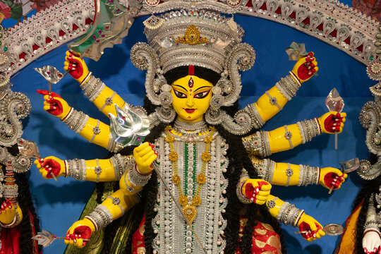 Narayanganj, Dhaka, Bangladesh - 20 October 2023: View of the intricately decorated idol of Goddess Durga during Durga Puja, featuring vibrant yellow skin, multiple arms, silver ornaments.