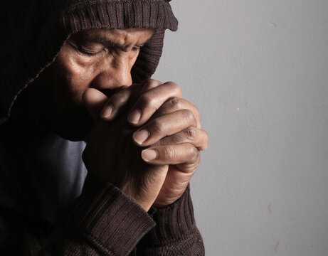 A serene portrait of a man praying with hands together in deep prayer that perfectly captures themes of faith, hope, mindfulness, and inner peace stock image stock photo