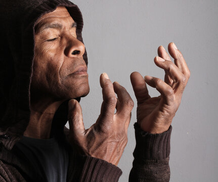 A serene portrait of a man praying with hands together in deep prayer that perfectly captures themes of faith, hope, mindfulness, and inner peace stock image stock photo