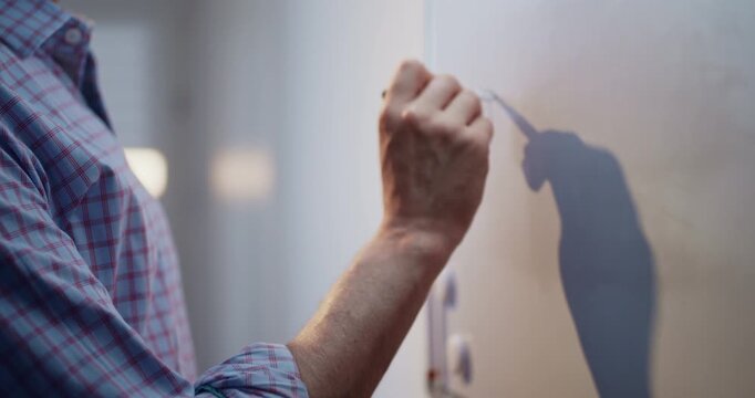 Man wearing a blue shirt writing the words &ldquo;Education Online&rdquo; on a whiteboard with a marker. Educational concept representing online learning, digital education, remote teaching, e-learning.