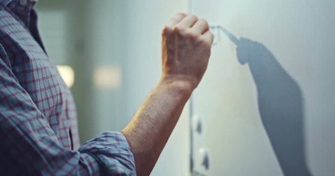 Man wearing a blue shirt writing the words &ldquo;Education Online&rdquo; on a whiteboard with a marker. Educational concept representing online learning, digital education, remote teaching, e-learning.