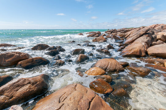 Turquoise waves washing over granite rocks in Western Australia