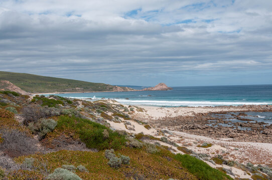 Western Australian beach with turquoise waves and rocky shore