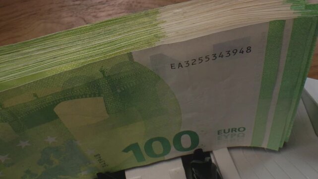 Macro shot of 100 Euro bills running through a counting machine